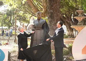 Carlos Soto revelando busto de mármol en parque público en la Ciudad de México.