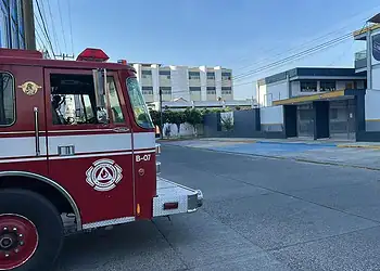 Fuego de emergencia en calle de la ciudad, vehículo de bomberos en acción, protección y seguridad pública.