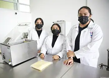 Personal de laboratorio femenino con batas y mascarillas en un entorno científico en México.
